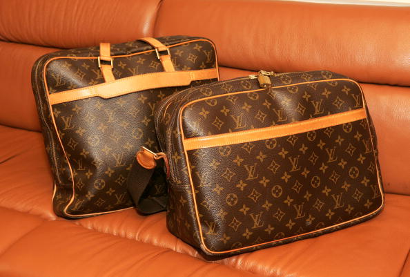 2 Louis Vuitton bags on an orange couch