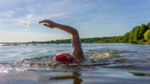 Woman swimming in a lake on a summer day