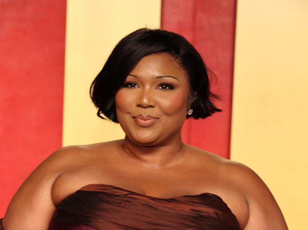 Lizzo attends the 2024 Vanity Fair Oscar Party wearing a brown sleeveless gown, Lawyer For Lizzo’s Dancers Calls Out Lizzo's ‘I Quit’ Post.