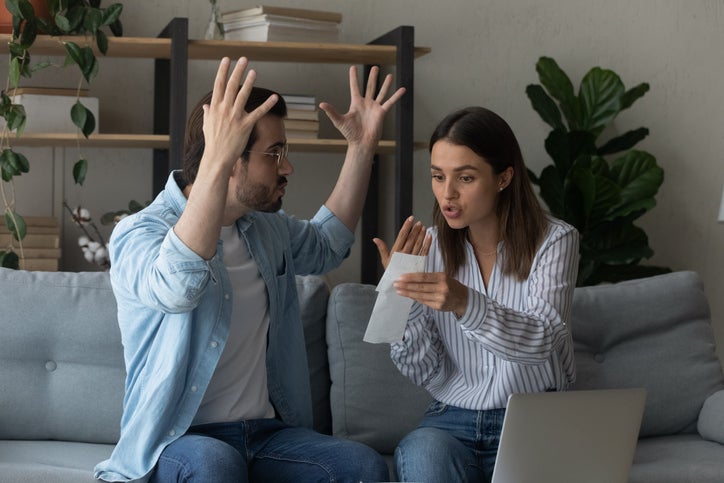 Stressed emotional couple arguing fighting when checking financial papers together finding unexpected debt lack of money on bank account. Mad angry husband scolding wife for overspending family budget Debt increasing