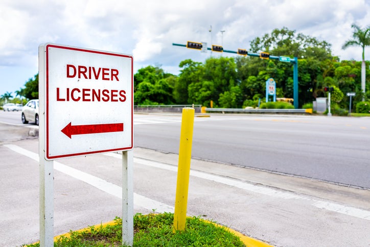 Naples, Florida downtown street empty road with roadside sign signpost for directions to driver license office for renewal or people who relocated. NCDMV Kiosks