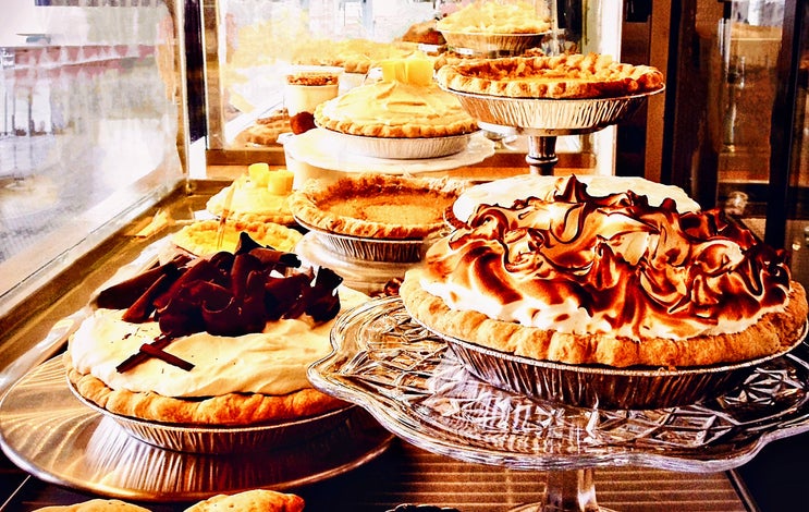 The ideal kitchen or coffee shop photo featuring a wide variety of pie…Meringue, Double Crust Fruit Filled, Boston Cream, Pumpkin, and a wide selection of quiches. Fall favorite pie