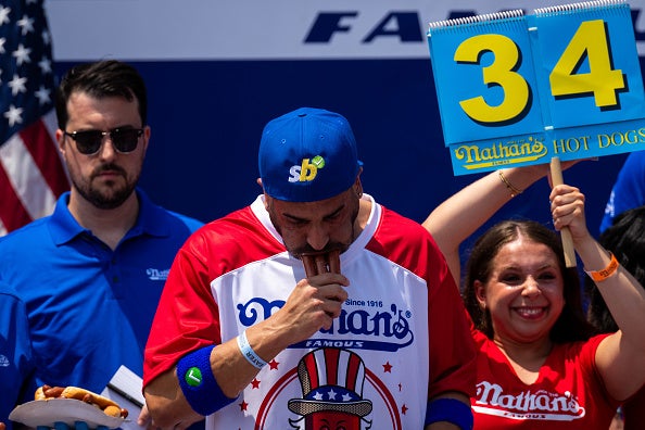 NEW YORK, NEW YORK - JULY 4: Participants compete for the mens title at Nathan's Annual Hot Dog Eating Contest on July 4, 2024 in New York City. Sixteen-time winner Joey Chestnut is banned from this year's contest due to his partnership with Nathan's competitor Impossible Foods, which sells plant-based hot dogs. Competitive eating