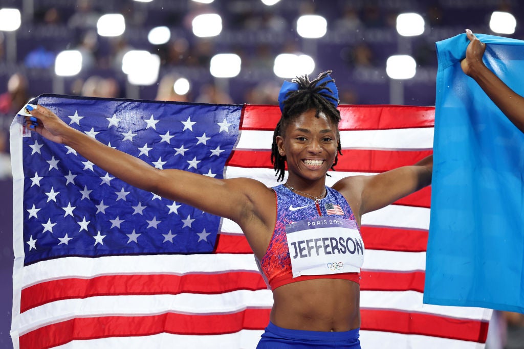 Coastal Carolina Alum Olympic Medal Win as Melissa Jefferson poses wrapped in an American flag after taking the bronze medal in her track and field event