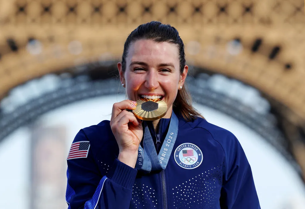 Gold medalist Kristen Faulkner of Team United States bites her medal on the podium during the Women's Road Race on day nine of the Olympic Games Paris 2024 at Trocadero. One venture capitalist turned Olympian has won a gold medal in Paris, and she started training later in life.