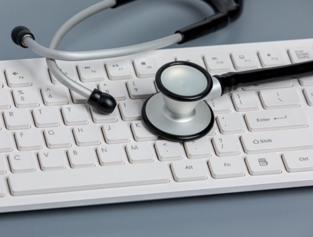 Stethoscope, computer keyboard. Medical records, data security, ransomware, and cyberattack concept. -