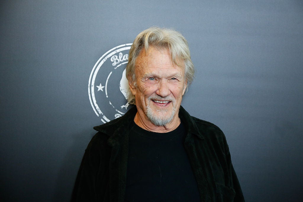 Kris Kristofferson in front of a grey background