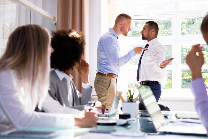 Stressed Businesspeople Sitting In Front Of Two Colleagues Fighting In Office Toxic jobs impact your health