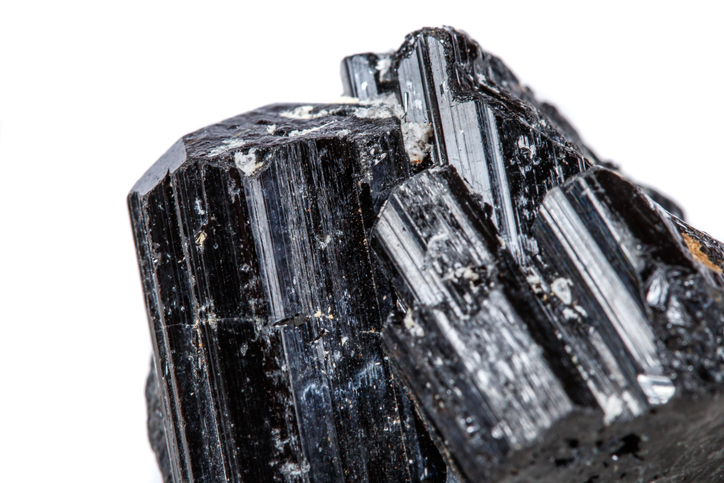 macro mineral stone sherle, schorl, black tourmaline on white background close-up